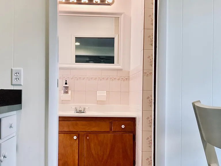 The downstairs bathroom is accessible from the kitchen, allowing for guest access through a sliding door.