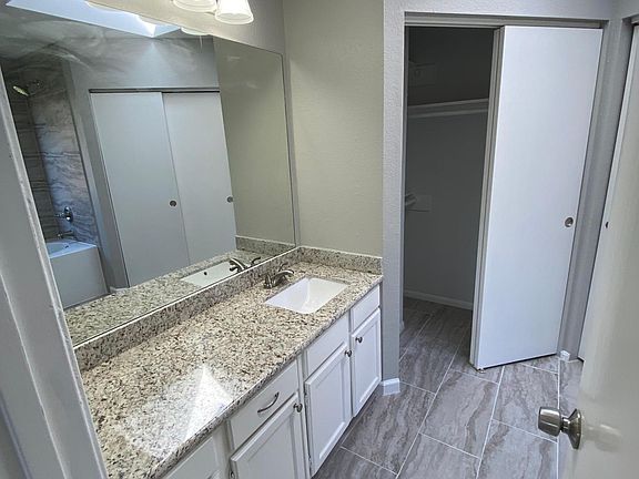 Master Bath with granite countertop and walk in his/her closets