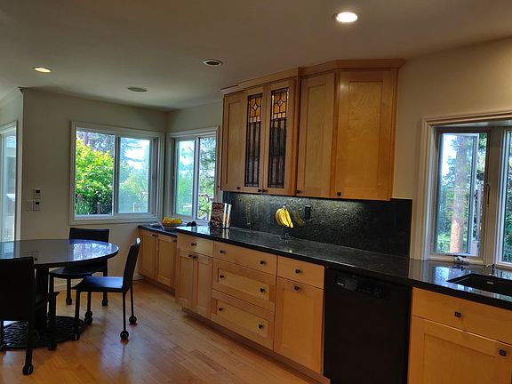 Lighted art class cabinet, natural stone kitchen counters, Miele dishwasher and ample storage