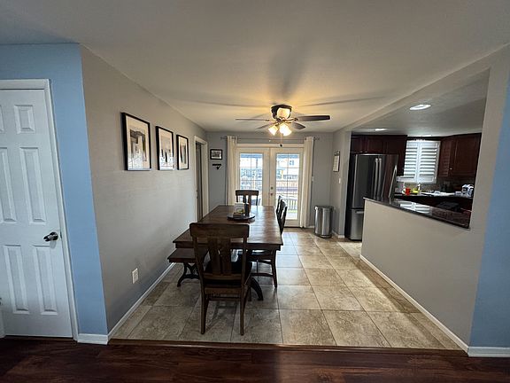 View of the coat closet and dining room from the living room, including the double doors to the covered back patio and backyard