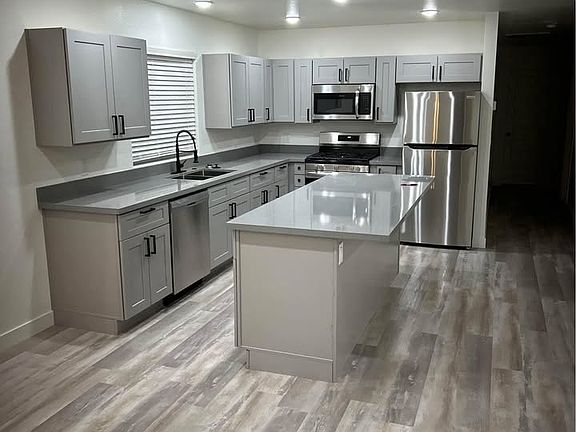 Kitchen and island with granite countertops and shaker style cabinets with soft close