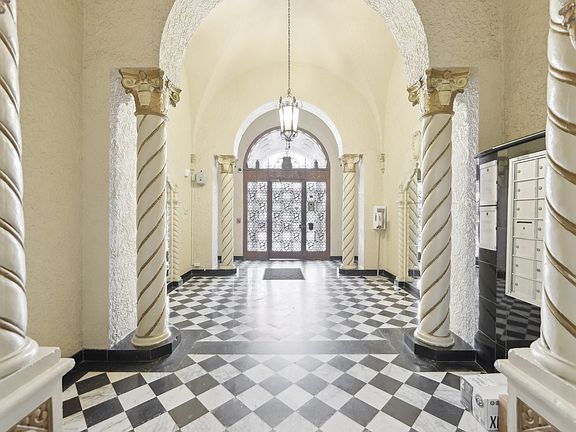 Hallway is illuminated by a chandelier hanging from the ceiling, casting a warm glow