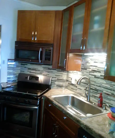 Kitchen includes custom backsplash, undercabinet lighting and stainless steel appliances (microwave, gas stove & oven, dishwasher, and refrigerator).