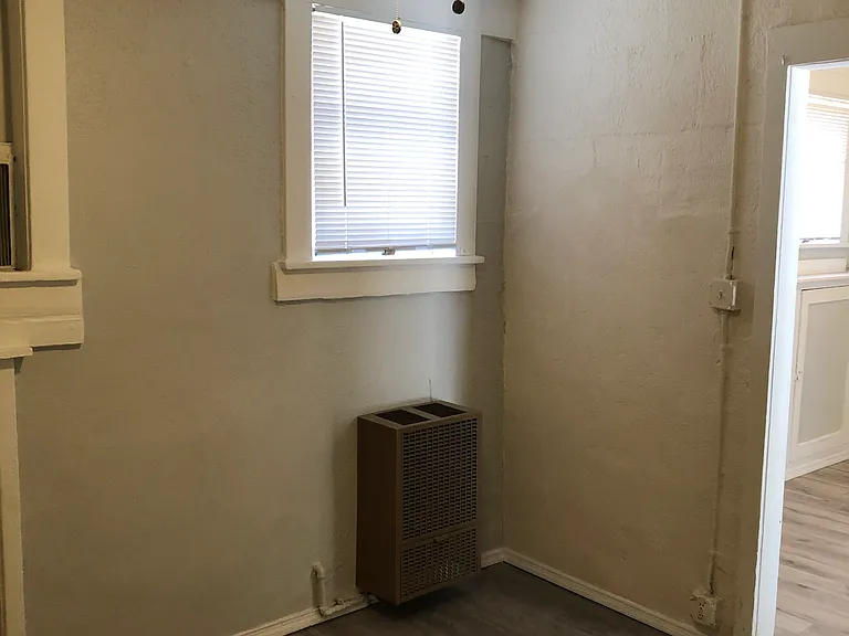 Photo presenting the bedroom area with includes a gas-powered heater and an electric window AC.