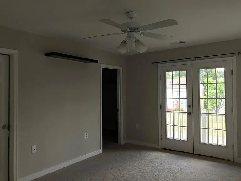 Master bedroom with doors to balcony and walk-in closet