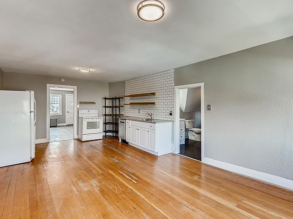Living room & kitchen space - quartz counters, floating shelves, hardwood floors