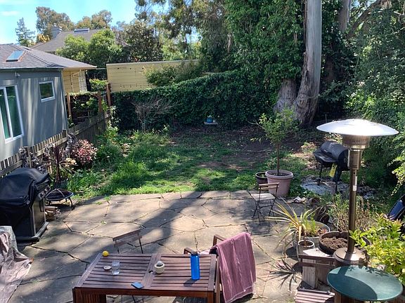 Kitchen window overlooking backyard with flagstone patio.