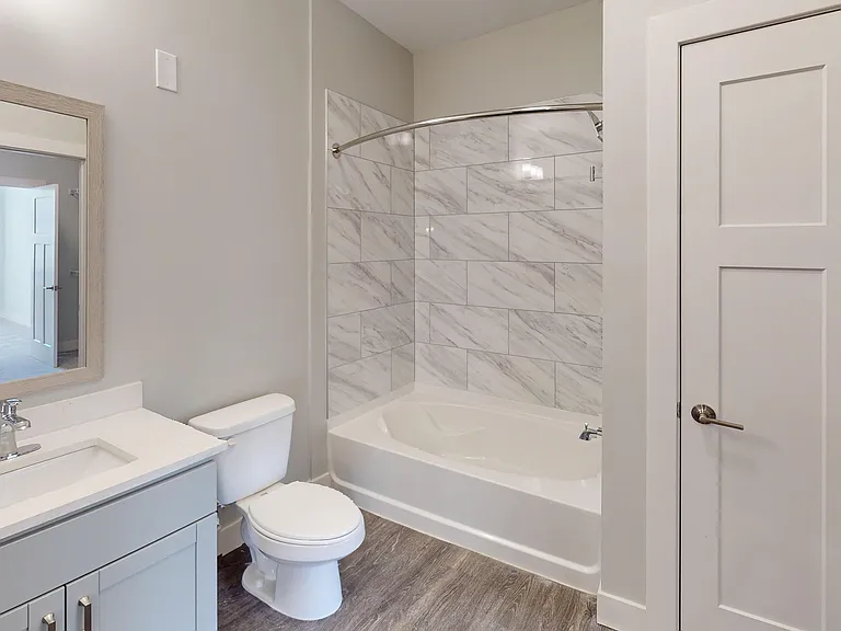 The bathroom in the Elm floor plan features a single sink with a large vanity, shower with a wide bathtub, and linen closet. The bathroom in the Elm floor plan features a single sink with a large vanity, shower with a wide bathtub, and linen closet.