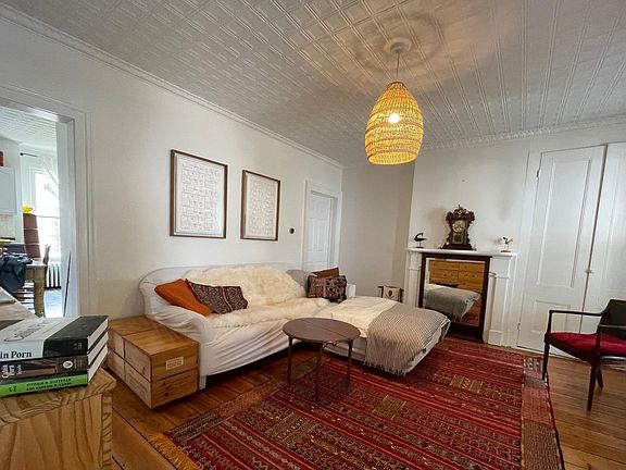 The living room (with sofa that can also be configured into a L-shape) leads to the kitchen/dining room on the left and a small bedroom/study on the right.