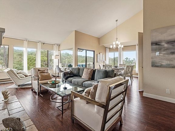 Windows abound in open space living area with 55" smart TV over fireplace.