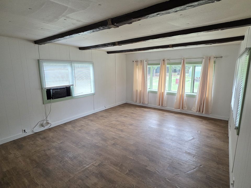 living room with window ac unit, large windows, new blinds, new drapes, new paint, new flooring