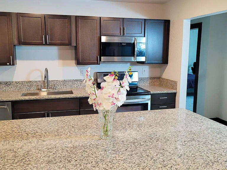 Beautiful wood cabinets with granite counters and bar stools around the large island