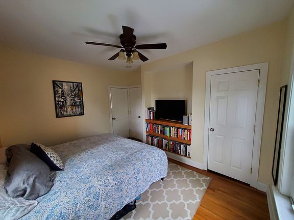 Bedroom 1 is located in the back of the house. King size bed pictured. Ceiling fan in the room. Built in shelves for TV/books. 1 larger closet, 1 smaller closet.