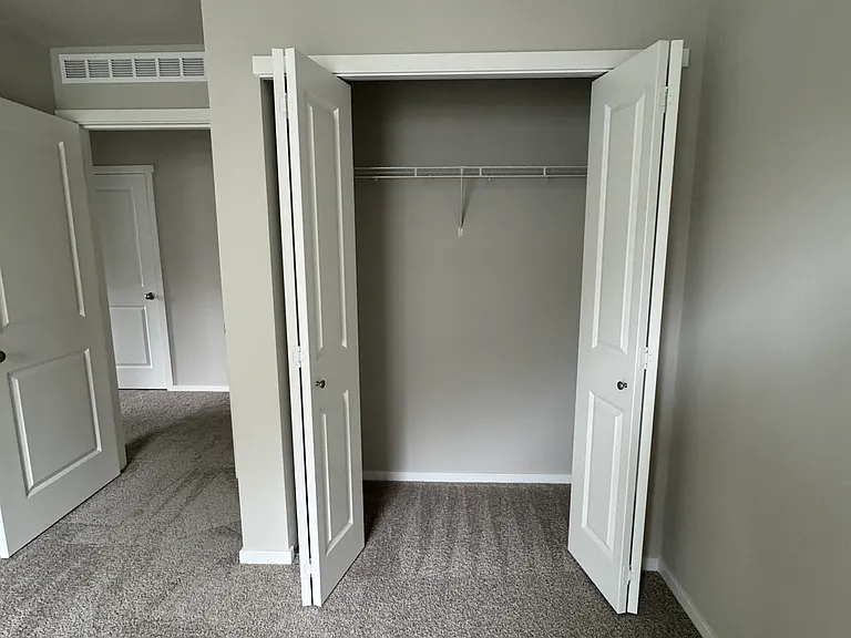 2nd bedroom. Image looking at the hall way toward hall closet (bathroom to the right of hall closet), 2nd bedroom's closet.