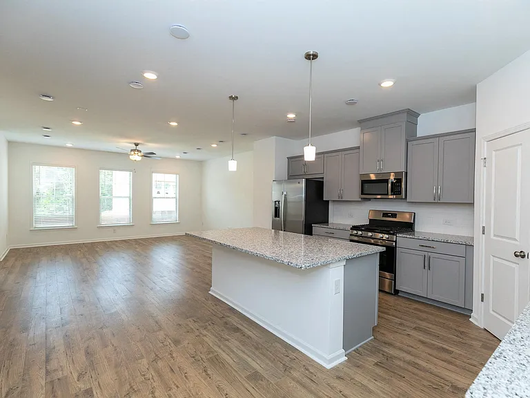 Sleek kitchen with gray cabinetry and granite countertops.