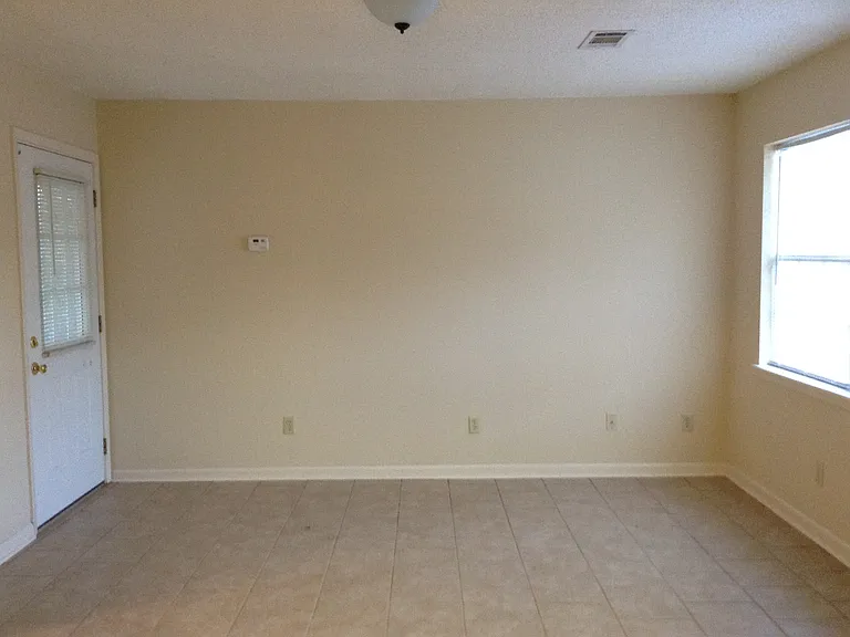 Another pic of living room. Double windows at front. Door leads to deck or patio.