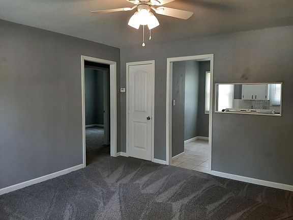 View from living room toward kitchen, living room closet, and interior hallway leading to bedrooms and bathroom