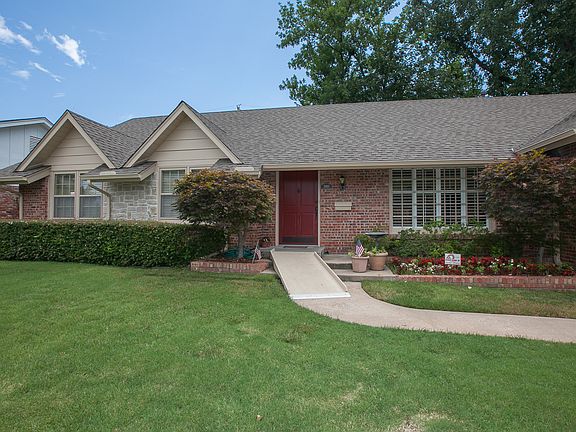 Beautiful oversized front door with fresh paint and nice large wood pane window in front.