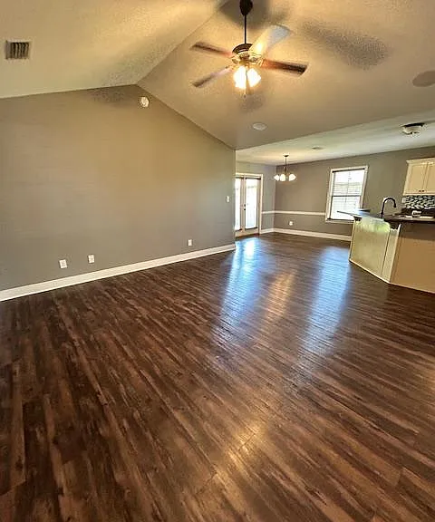 Entry way leads into the living room with vaulted ceilings and an open kitchen concept