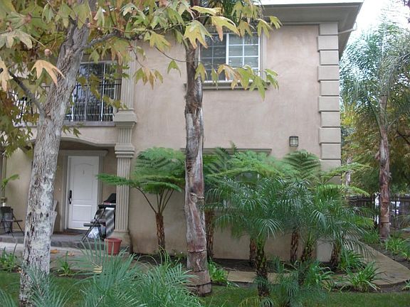 Corner building has 2 impressive lush landscapes.