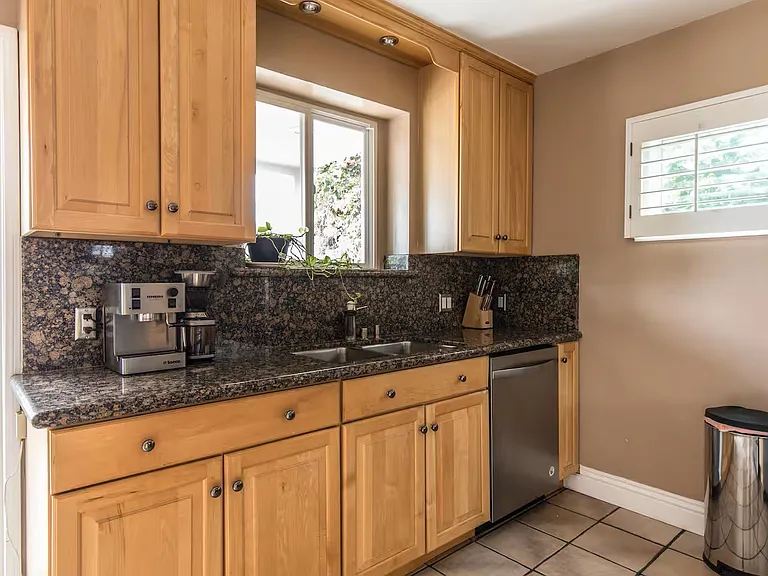 Kitchen has granite countertops and backsplash.