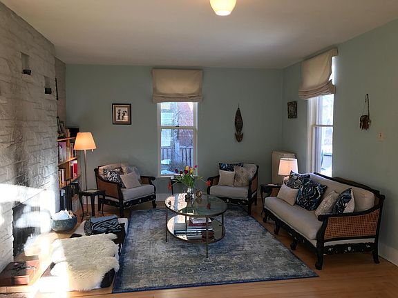Other side of living room, custom window coverings included. Has gas fireplace insert, not shown here, steam heath radiators.