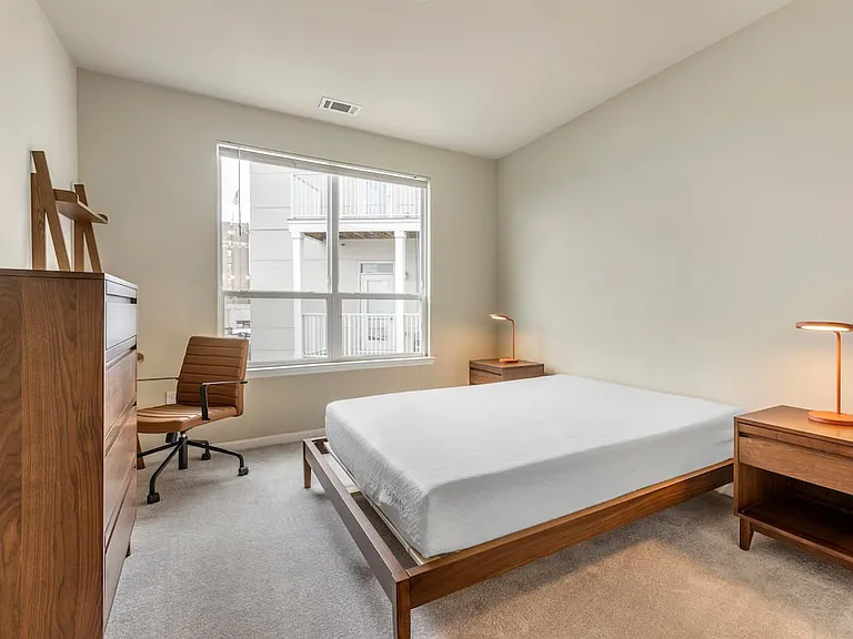 Furnished+ apartment homes feature queen bed with mattress, dresser, nightstands, lamps, and an office desk and chair (Representative Image exact items and style of furnishings may vary)