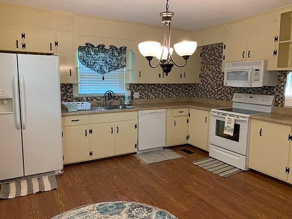 Kitchen, dishwasher, fridge w/ice maker, stove w/ceramic cooktop, open shelving.