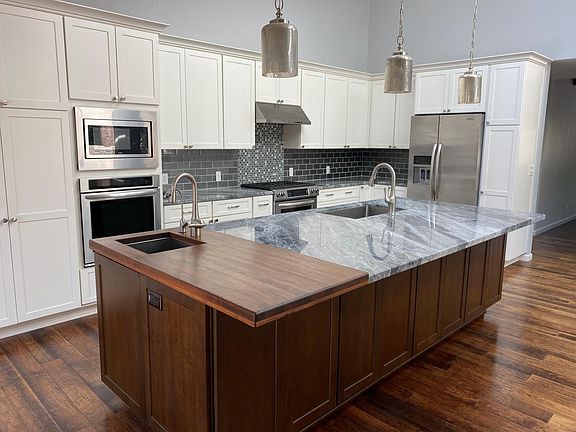 Kitchen Island with wet bar/prep sink. All stainless steel appliances. Microwave and Separate oven. Gas range with oven. Side by side fridge with ice and water.