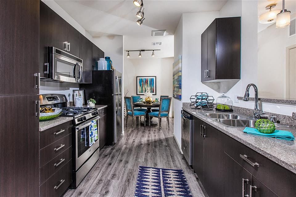 Dark wood tone cabinets and clean steel appliances give your kitchen a modern feel