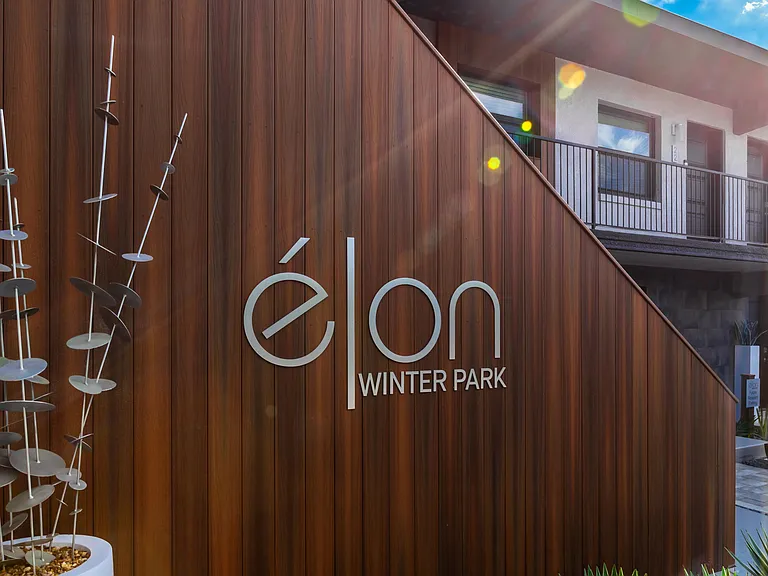 The stylish exterior signage at Elon Winter Park Apartments embodies modern sophistication, complementing the community's contemporary design and inviting atmosphere.