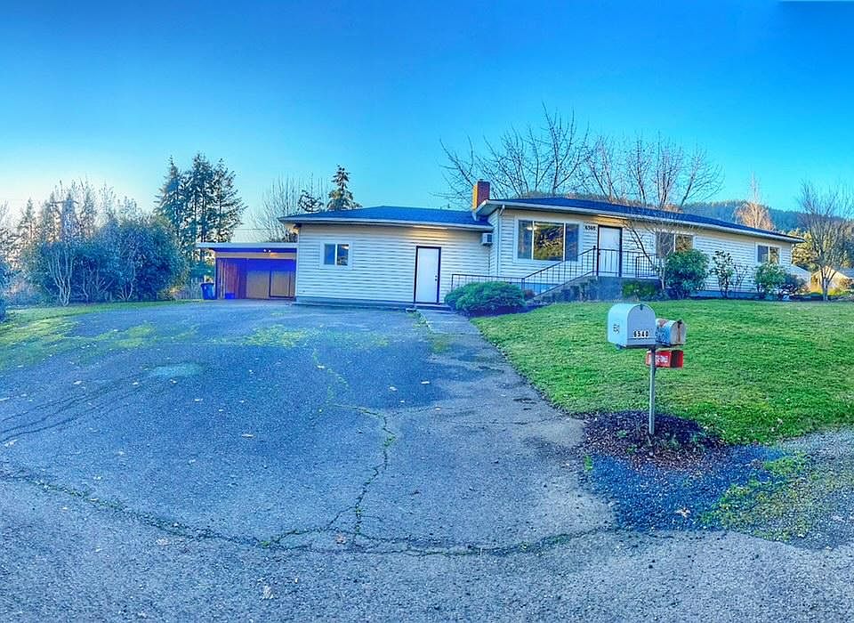 Street view with large driveway and front yard.