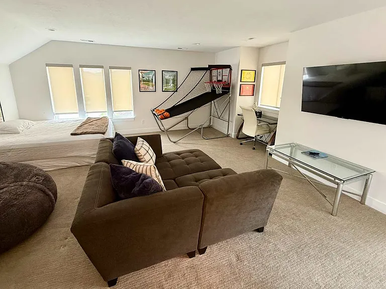 Upstairs studio recreation room with king sized bed, large bean bag and sectional couch, basketball game, smart tv and electric piano