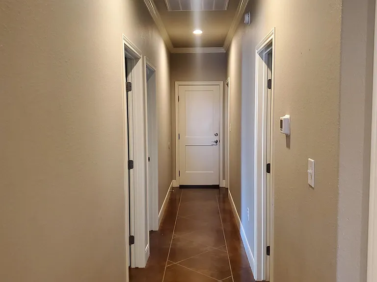 Hallway leading to the 2nd bath room, 2nd & 3rd bedrooms, laundry room, and two car garage.