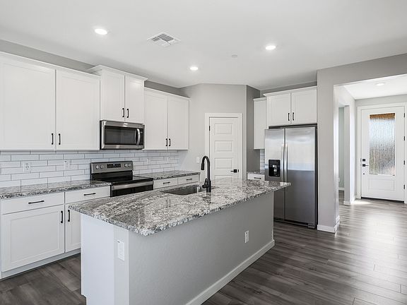 Chef-ready kitchen with white cabinets and stainless steel appliances.