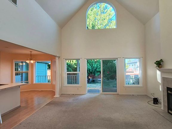 Living room with view to kitchen and informal dining as well as back porch and yard