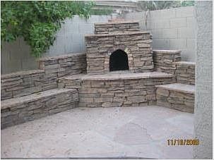 stone fire place with built in seating and stone barbecue