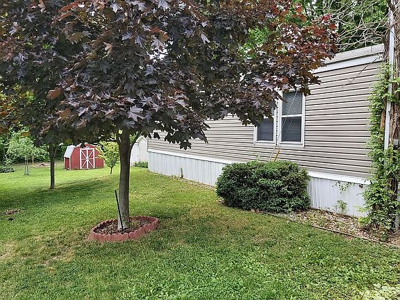 Red shed in back with mower.