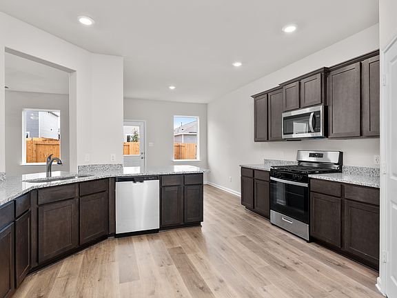 The kitchen has designer wood cabinetry.