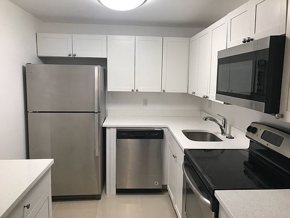 Brand new white kitchen with granite counter tops and SS appliances