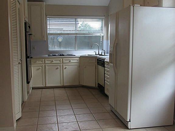 Kitchen view from breakfast area. Large windows open to back