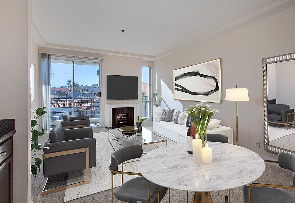 Staged and carpeted living room with fireplace and sliding door leading to balcony.