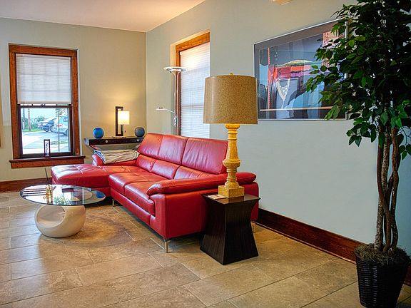 Living room and red leather sectional couch. Not shown: another TV and additional seating.
