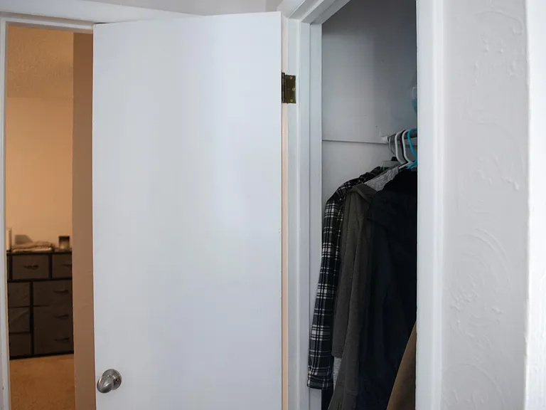 storage/coat closet in hall leading to back bedroom