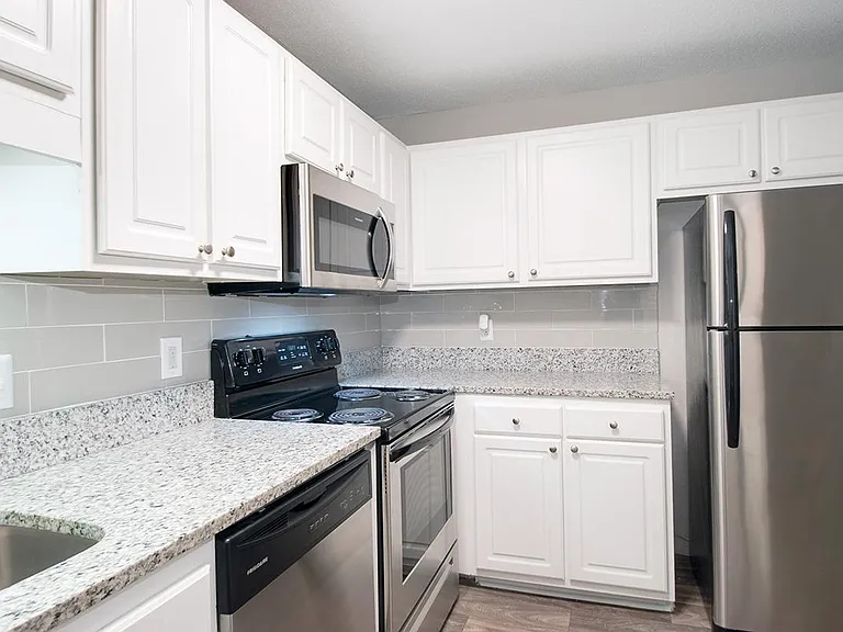 GRANITE COUNTERTOPS AND STAINLESS STEEL APPLIANCES IN KITCHEN
