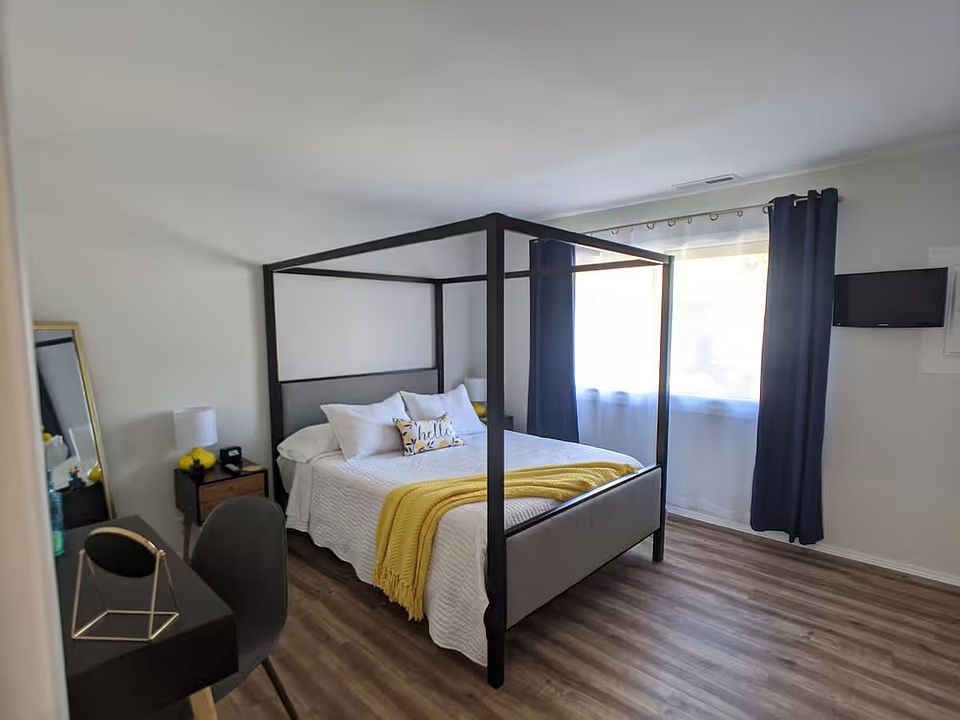 Large spacious bedroom with a queen size Sealy Posturepedic (Tempur pedic) bed. A flatscreen Roku Smart TV, black out blinds, a laptop desk and/or vanity, and luggage racks.