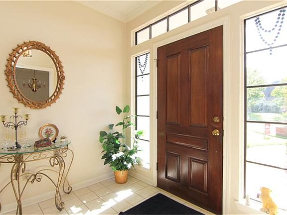 Beautiful solid wood door and tile floor in the entry.
