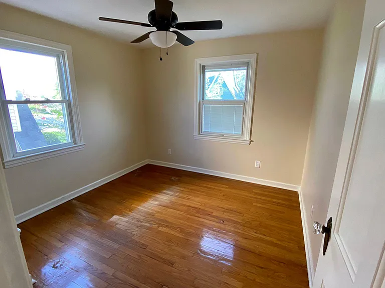 3rd bedroom with hardwood floors, cedar closet, ceiling fan, built-in bookcase & cedar closet