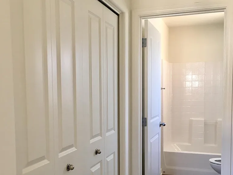 Laundry area behind the folding doors is conveniently located near the bedrooms and shared bathroom on the second floor.
