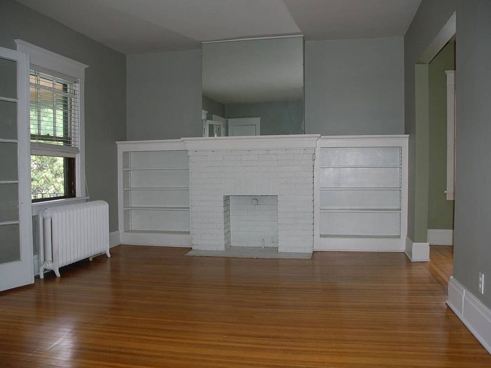 living room with built-ins and refinished hardwood throughou